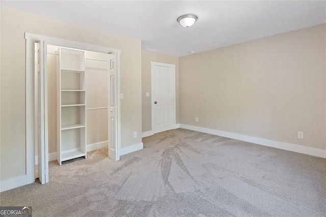 unfurnished bedroom with light carpet and a closet