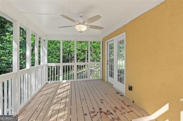 unfurnished sunroom with ceiling fan