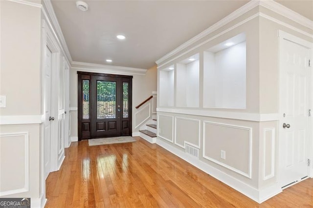 entrance foyer featuring light hardwood / wood-style flooring and ornamental molding