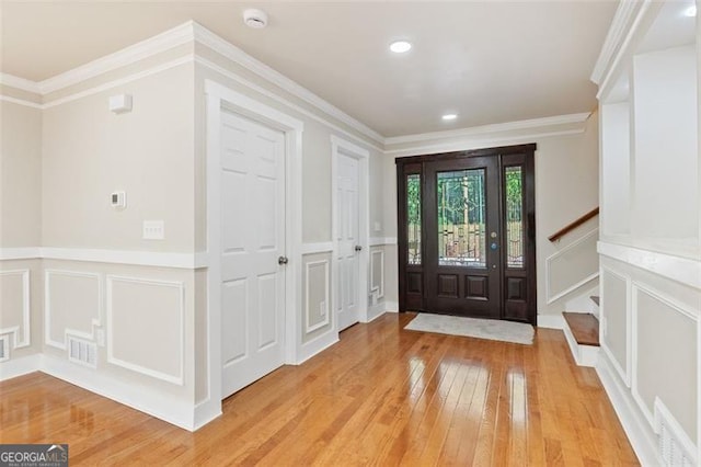 foyer entrance featuring light hardwood / wood-style flooring and ornamental molding