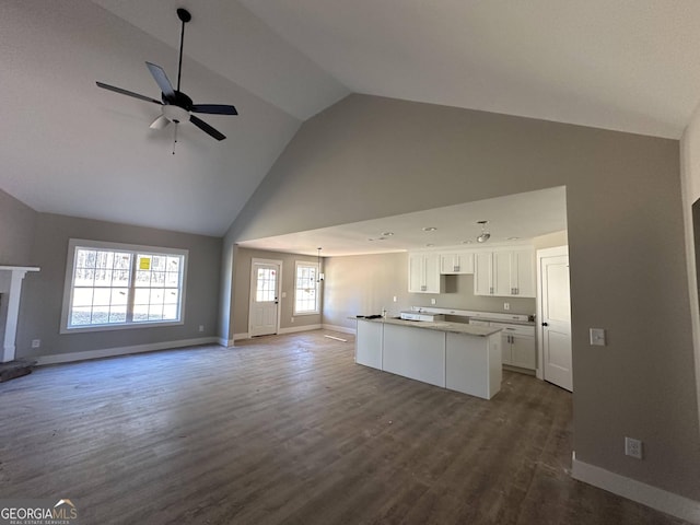 unfurnished living room featuring hardwood / wood-style flooring, ceiling fan with notable chandelier, and lofted ceiling