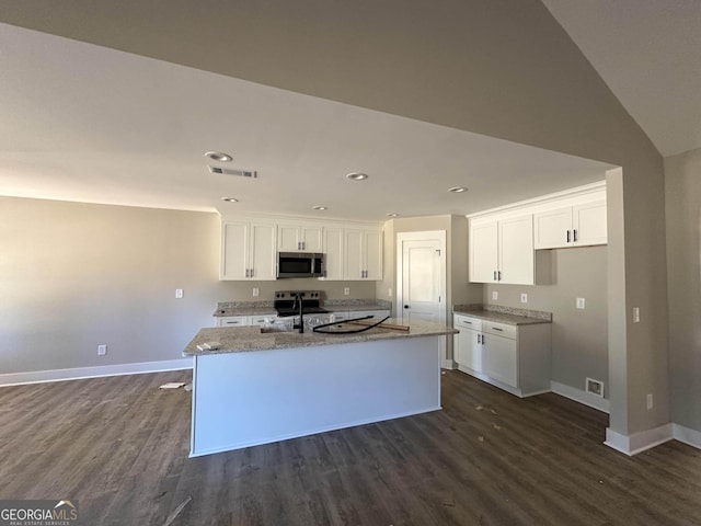 kitchen with white cabinetry, a kitchen island with sink, sink, and light stone counters