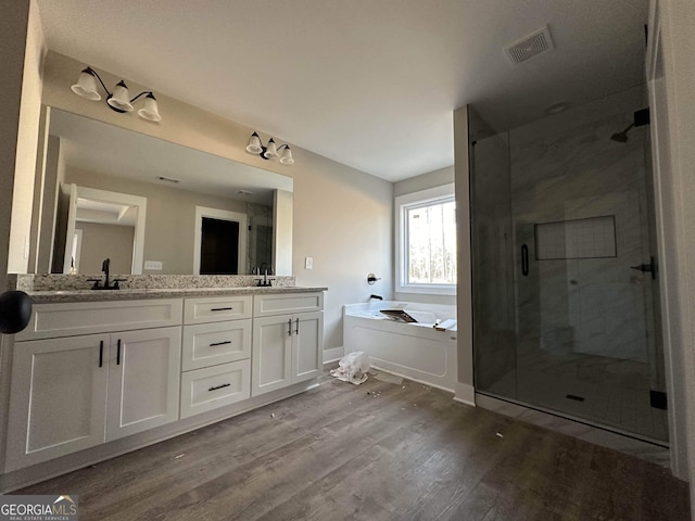 bathroom with hardwood / wood-style flooring, vanity, and independent shower and bath