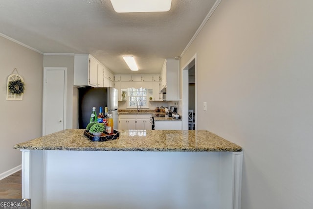 kitchen featuring light stone counters, stainless steel appliances, and white cabinetry