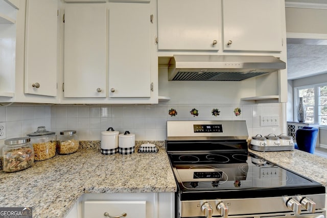 kitchen with stainless steel range with electric stovetop, decorative backsplash, wall chimney range hood, and white cabinetry