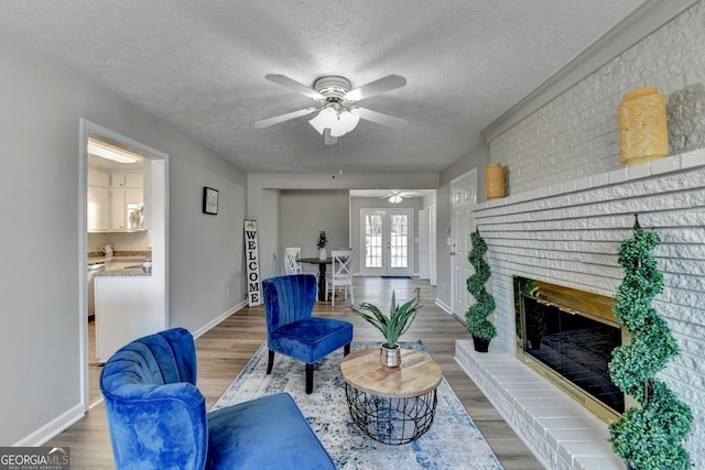 living room featuring a fireplace, a textured ceiling, french doors, and wood-type flooring