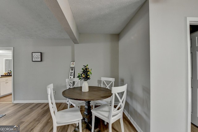 dining area featuring a textured ceiling and light wood-type flooring