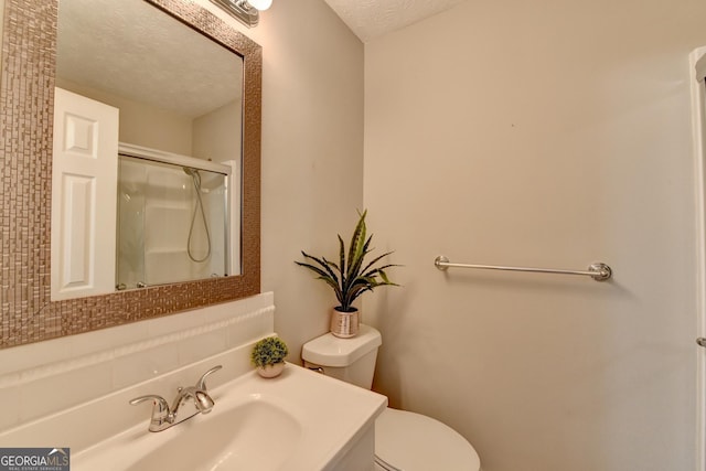 bathroom with sink, a shower with door, a textured ceiling, and toilet