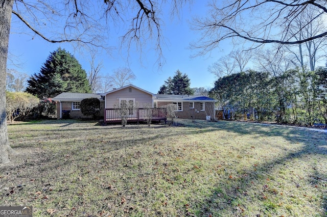 view of front of home featuring a front yard and a deck