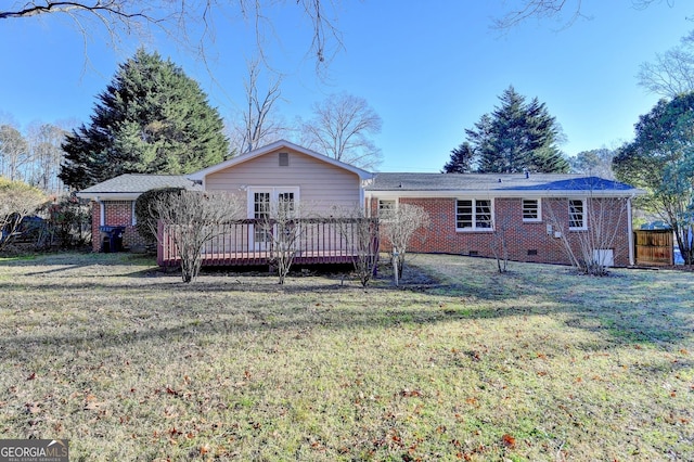 rear view of house featuring a lawn and a deck