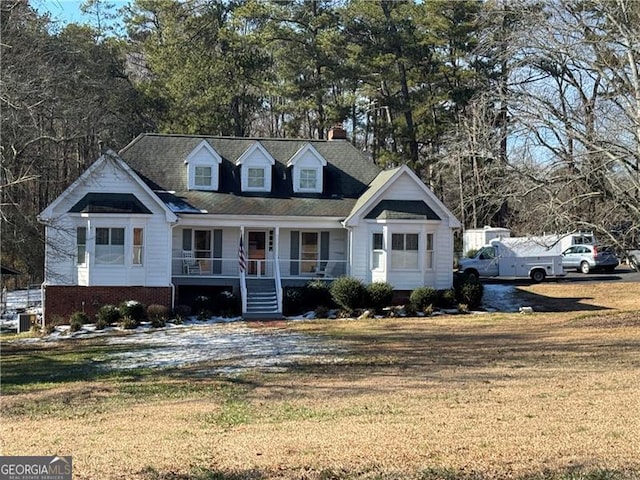 new england style home with a front yard and a porch