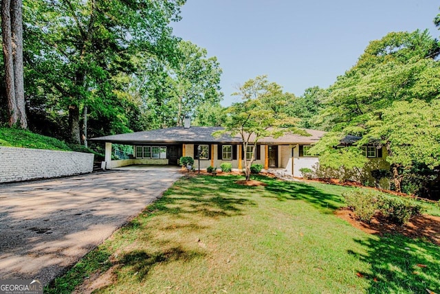 ranch-style home with a front yard and a carport