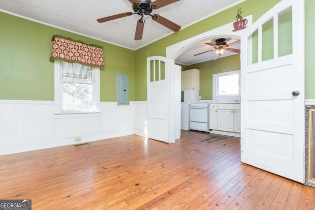 unfurnished room featuring a textured ceiling, light hardwood / wood-style floors, and crown molding