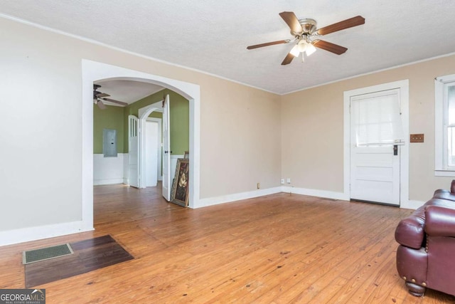 unfurnished living room featuring hardwood / wood-style flooring, ceiling fan, a textured ceiling, and electric panel