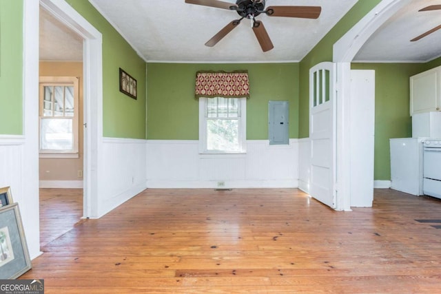 interior space with a textured ceiling, ceiling fan, crown molding, light hardwood / wood-style flooring, and electric panel