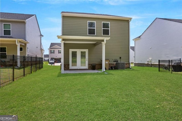 rear view of property featuring central air condition unit, a yard, and french doors