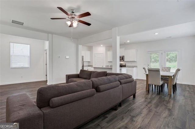 living room featuring dark hardwood / wood-style floors and ceiling fan