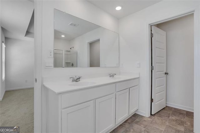 bathroom with vanity and a shower with door