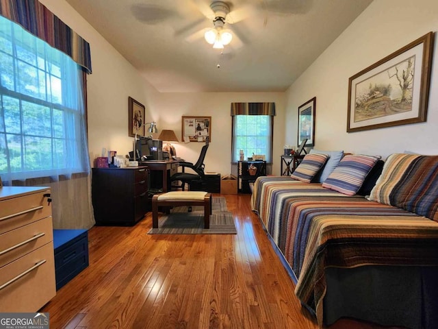 bedroom with multiple windows, ceiling fan, and light hardwood / wood-style floors