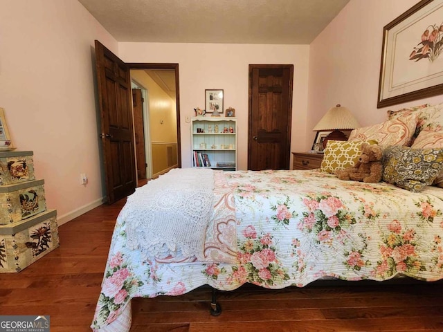 bedroom with dark hardwood / wood-style flooring