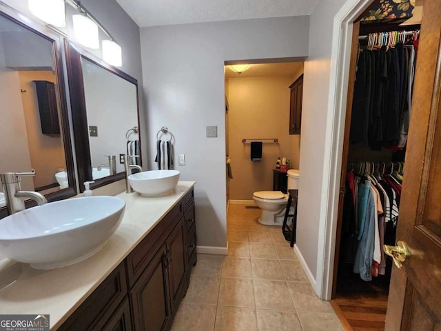 bathroom featuring toilet, vanity, and tile patterned floors