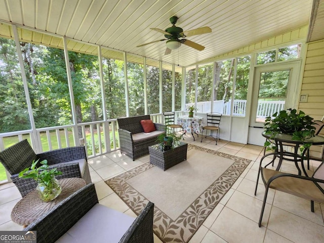 sunroom / solarium featuring ceiling fan, plenty of natural light, and wood ceiling