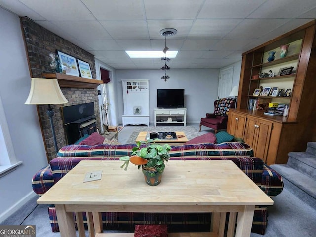 living room featuring carpet and a drop ceiling