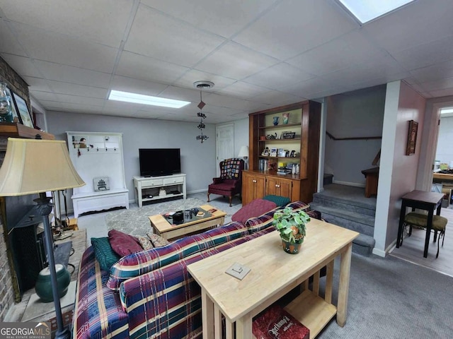 living room with a drop ceiling and carpet floors