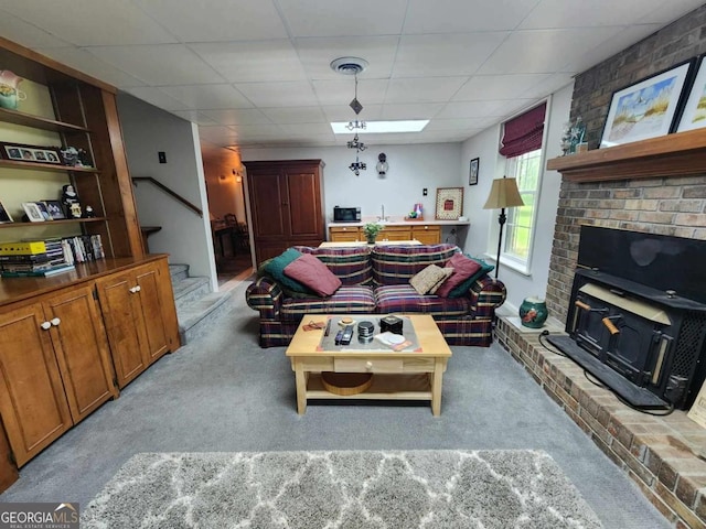 living room with a drop ceiling, sink, and light carpet