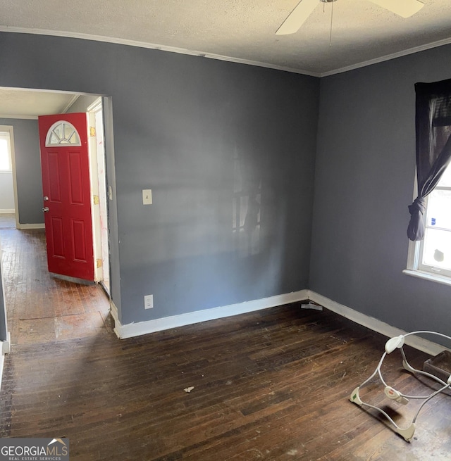 foyer entrance featuring ornamental molding, dark wood-type flooring, and ceiling fan