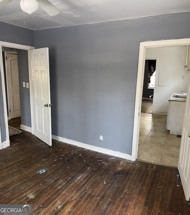 empty room featuring sink, ceiling fan, and dark hardwood / wood-style floors