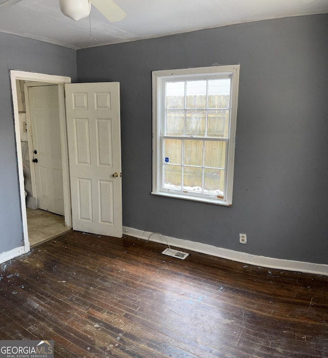 empty room with ceiling fan and dark hardwood / wood-style flooring