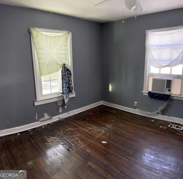 empty room featuring ceiling fan, dark hardwood / wood-style flooring, and cooling unit