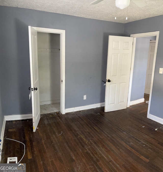 unfurnished bedroom with a closet, a textured ceiling, ceiling fan, and dark hardwood / wood-style flooring