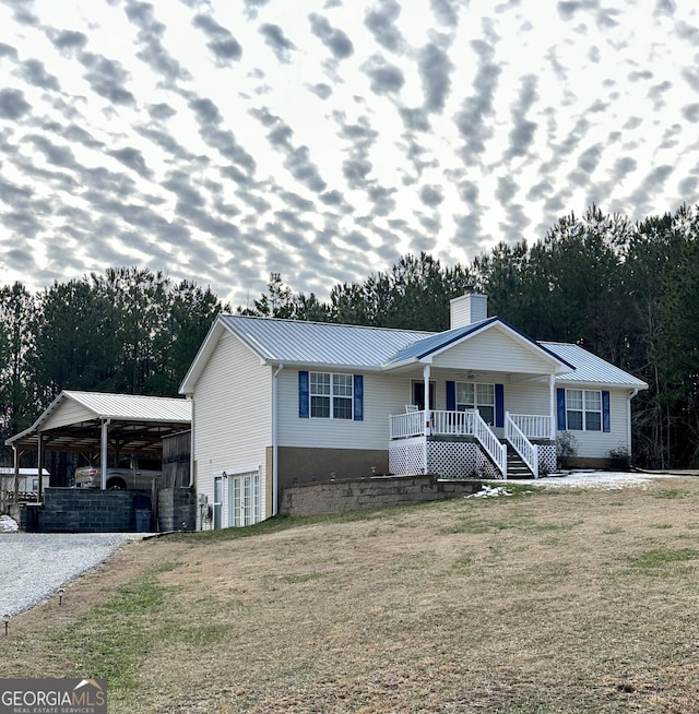 ranch-style house featuring covered porch and a front lawn