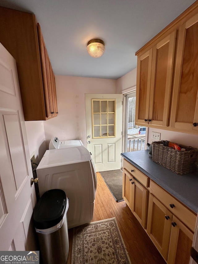 laundry area with cabinets, washer and clothes dryer, and light wood-type flooring