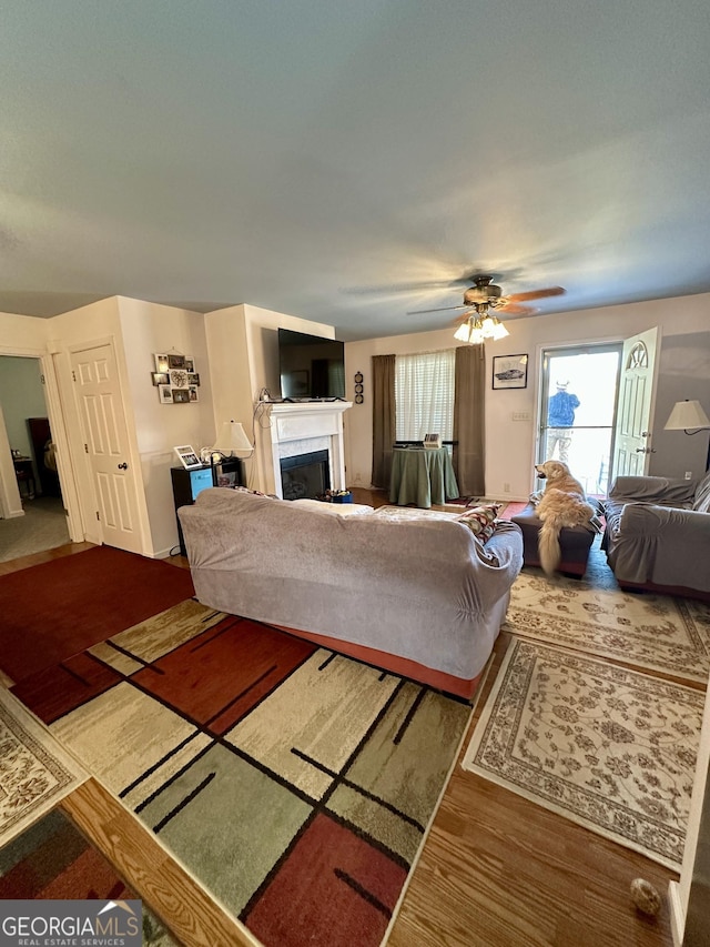 living room featuring wood-type flooring and ceiling fan