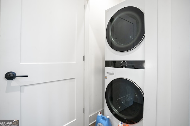 clothes washing area with stacked washing maching and dryer