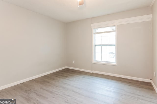 spare room with ceiling fan and light wood-type flooring