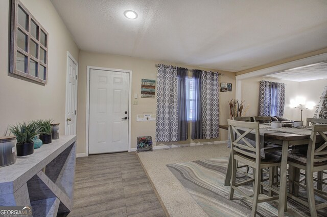 carpeted living room with ceiling fan and a textured ceiling