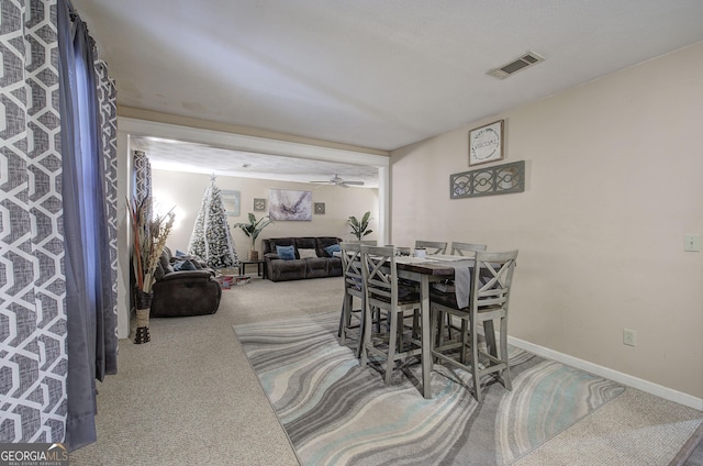 dining room with carpet floors, visible vents, and baseboards