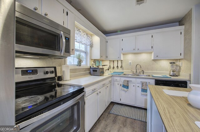 kitchen with white cabinets, dark hardwood / wood-style flooring, stainless steel appliances, and a kitchen island