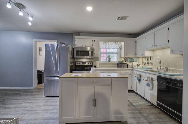 kitchen featuring light countertops, visible vents, appliances with stainless steel finishes, white cabinetry, and wood finished floors