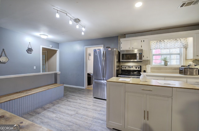 kitchen featuring tasteful backsplash, visible vents, wooden counters, appliances with stainless steel finishes, and light wood-style floors