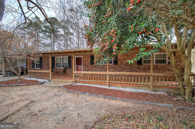 ranch-style house with covered porch and brick siding