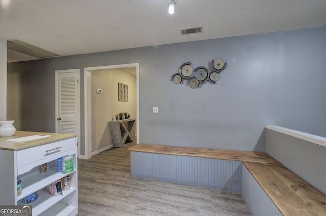 hallway with wood finished floors and visible vents