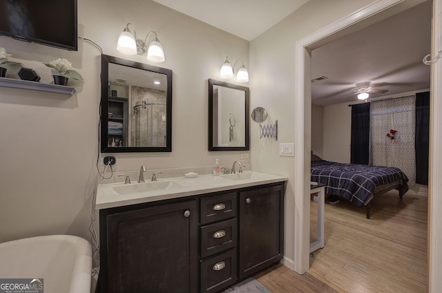 bathroom featuring double vanity, visible vents, a sink, and wood finished floors