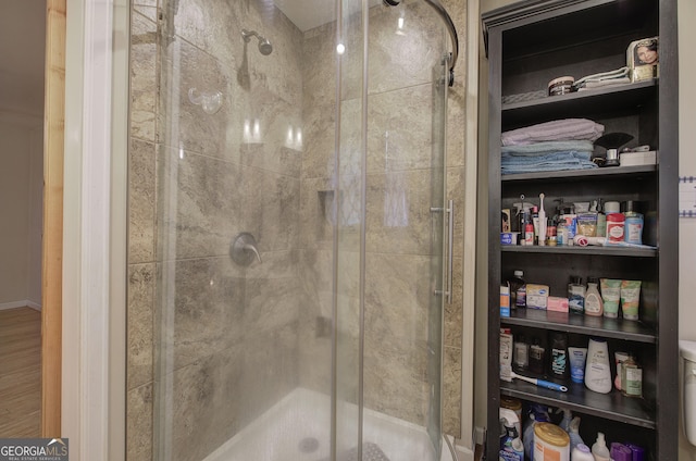 full bathroom with wood finished floors and a shower stall