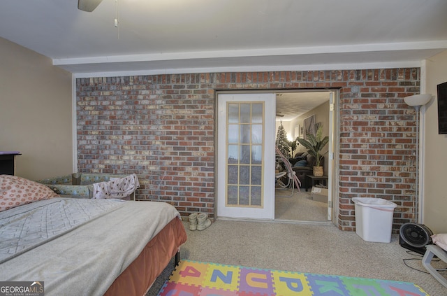 bedroom featuring carpet floors, brick wall, and a ceiling fan