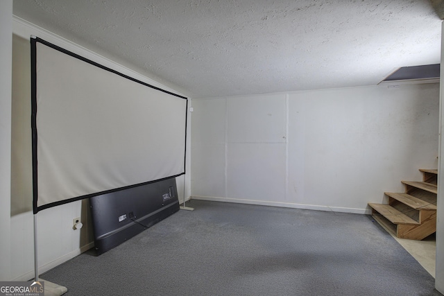 home theater featuring a textured ceiling, carpet, and baseboards